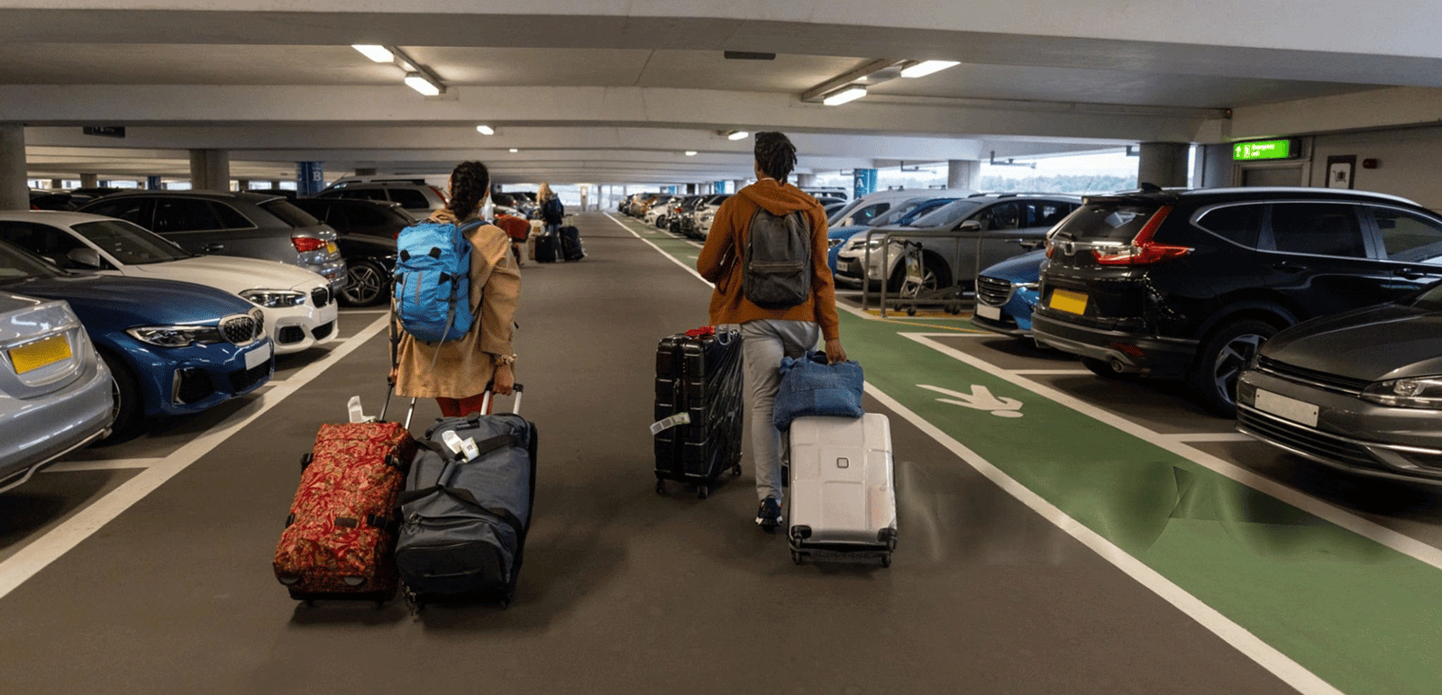 people walking in airport car park